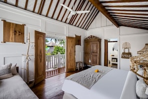 Ein Schlafzimmer mit einem Bett, einem Holzschrank und einem Balkon mit Blick.