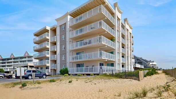 Ein mehrstöckiges Hotel mit Balkonen in der Nähe eines Sandstrandes.