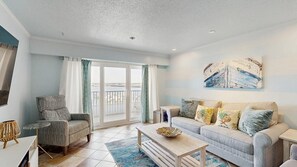 A living room with a sofa, armchair, coffee table, and artwork on the wall. - White Marlin 405B (Ocean City)