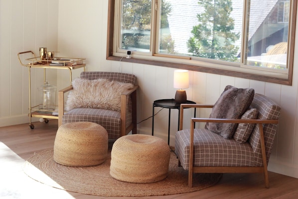 Une pièce confortable avec vue, comprenant un canapé, des poufs, une lampe et une petite table avec une lampe.