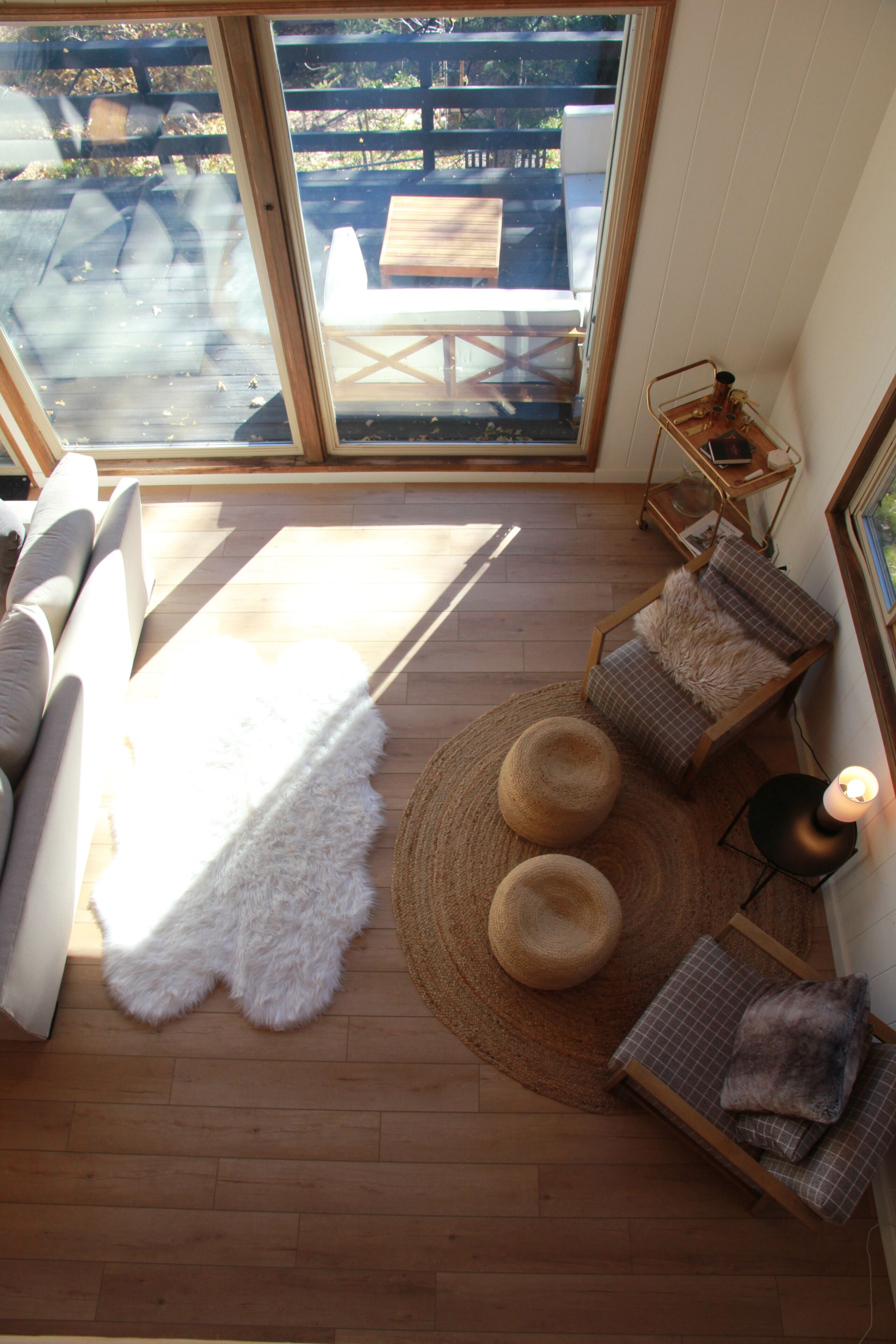 Une pièce comprenant un canapé, un fauteuil, un tapis rond et une petite table avec une lampe.