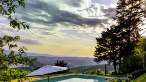 A rectangular swimming pool with a view of mountains in the background.