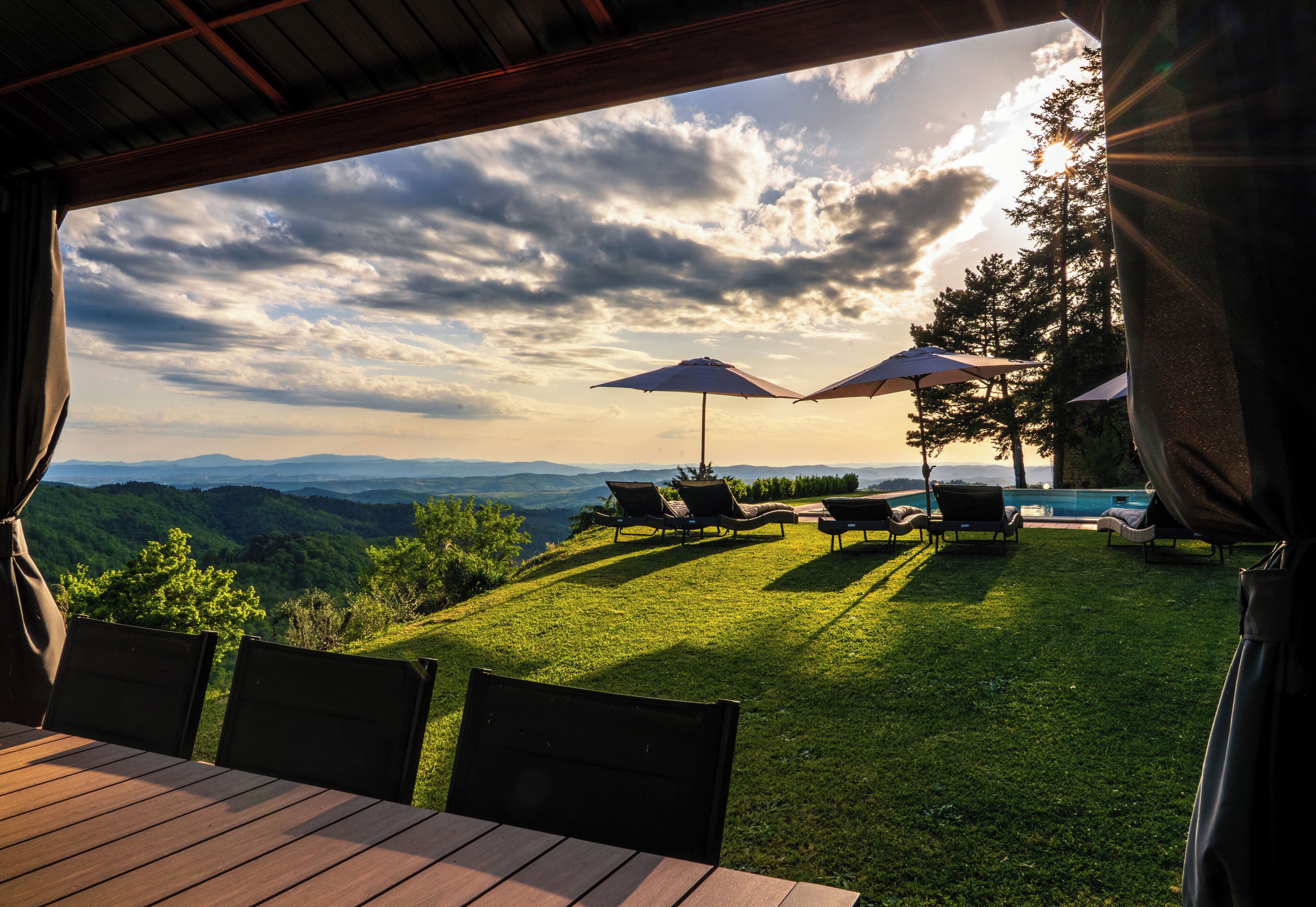 Une terrasse avec des sièges extérieurs et une vue sur les montagnes.