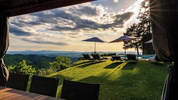 Une terrasse avec des sièges extérieurs et une vue sur les montagnes.