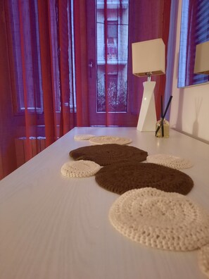 A room with a long table, a lamp, and a window with curtains. - Domus Velia Central Apt | Just Steps from the Station, Port, and Old Town (Salerno)