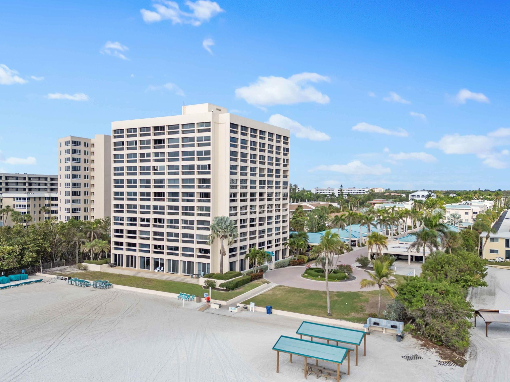A multi-story hotel with a central courtyard, outdoor seating, and a pool area.