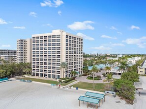Un hôtel à plusieurs étages doté d’une cour intérieure, d’un espace extérieur aménagé pour s’asseoir et d’un espace piscine.