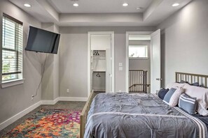 A bedroom with a bed, a TV mounted on the wall, a closet, and a window with blinds. - 3-bedroom SFR in fabulous Houston with cool AC (Houston)
