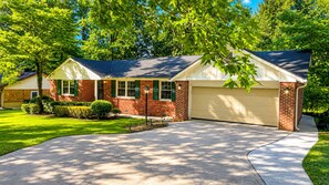 A two-story house with a garage, a driveway, and a well-maintained lawn.