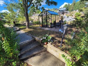 A garden with a gazebo, a small water feature, and a patio area with outdoor furniture. - A lush, authentic setting surrounded by nature, yet close to both the city and the archipelago! (saltsjo-boo)