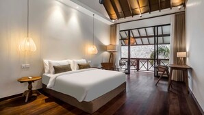 Ein modernes Hotelzimmer mit einem großen Bett, zwei Nachttischlampen, einem Schreibtisch und einem Balkon mit Blick.