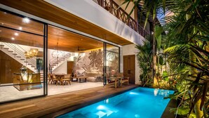 A modern house with a swimming pool, wooden deck, and tropical plants. - Nusantara Loft Rote in Pererenan (Pererenan)