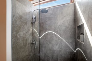 A modern shower with a glass enclosure, a handheld showerhead, and a wall-mounted faucet. - Nusantara Loft Raijua (Pererenan)