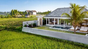 A modern house with a swimming pool, a covered patio, and a lush green field. - Villa Grateful in Kecamatan Sukawati (Kecamatan Sukawati)