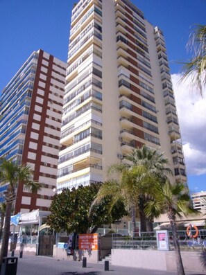 A tall, multi-story building with balconies, a clear sky, and palm trees. - Miramar Playa 6-2 in Benidorm (Benidorm)