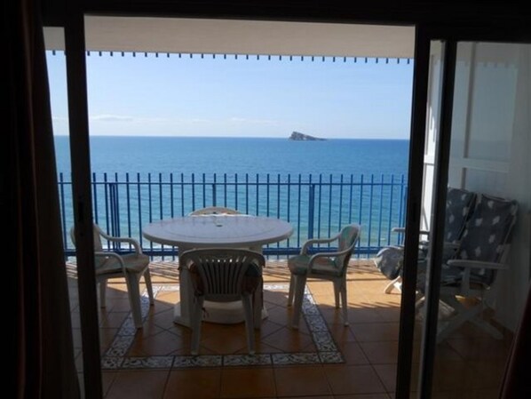 A balcony with a view of the sea, a round table, and chairs. - Palmeras 9D in Benidorm (Benidorm)