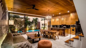 Ein modernes Interieur mit Essbereich, Küche und Blick auf einen Pool.
