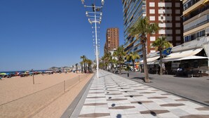 Una passeggiata sul lungomare con un pavimento decorato, palme e edifici con balconi.