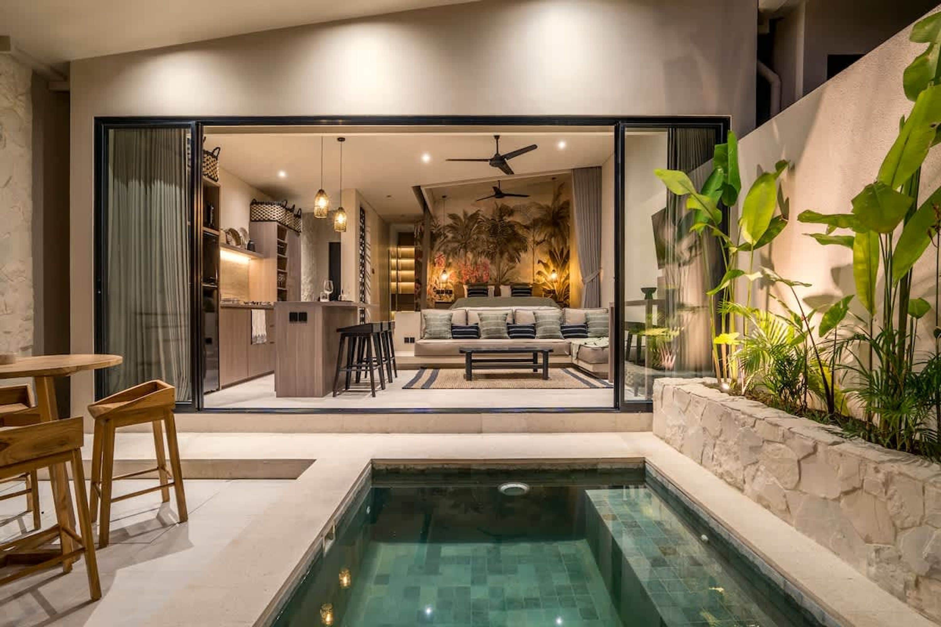 Ein modernes Interieur mit Pool, Essbereich und Wohnbereich mit Sofa und Couchtisch.