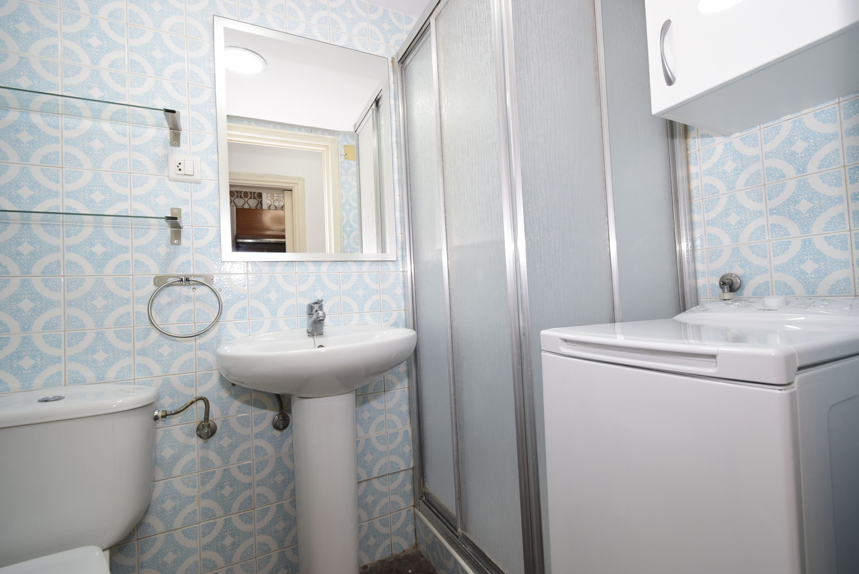Un baño con inodoro, lavabo y ducha.