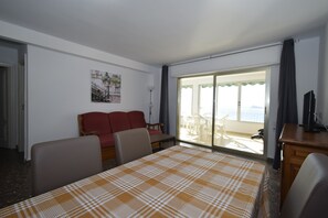 Habitación de hotel con cama, sofá, escritorio y balcón con vistas.