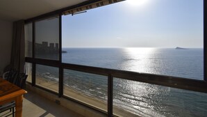 Una stanza con un'ampia finestra vista spiaggia e mare.