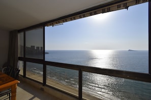 Ein Zimmer mit einem großen Fenster mit Blick auf einen Strand und den Ozean.