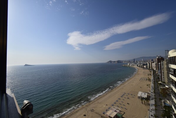 Eine Küstenstadt mit Strand, Gebäuden und blauem Himmel.