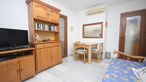 A room with a bed, a wooden cabinet with books, a television, a desk with a chair, and a mirror on the wall. - Cachirulo 4A in Benidorm (Benidorm)