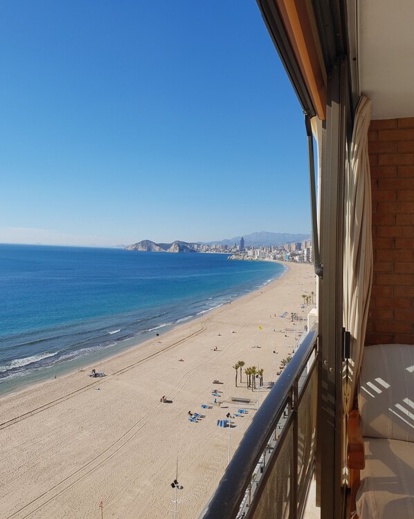 A beach view from a balcony with a clear sky, a sandy beach, and a cityscape in the distance. - Cachirulo 4C in Benidorm (Benidorm)
