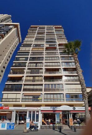 A multi-story hotel with balconies, a palm tree, and a ground-level snack bar and restaurant. - Cachirulo 4C in Benidorm (Benidorm)