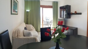 A dining area with a round table, a sofa, a cabinet, and a door. - Cachirulo 4C in Benidorm (Benidorm)