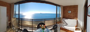 A balcony with a view of the sea, a table with a vase of flowers, and a sofa. - Cachirulo 4C in Benidorm (Benidorm)