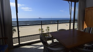 A room with a large window overlooking a beach, a wooden table, and a chair. - Cachirulo 3B in Benidorm (Benidorm)