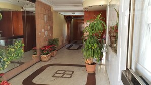 A hotel corridor with wooden paneling, potted plants, and a marble floor with a geometric pattern. - Cachirulo 3B in Benidorm (Benidorm)