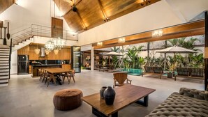 A spacious living area with a dining table, sofas, and a poolside setting. - Villa Nusantara 3 in Pererenan (Pererenan)