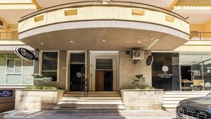 Un edificio con una entrada curva, un letrero de bar-lounge y un letrero de boutique de lavandería.