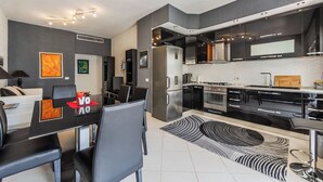 Cocina moderna con comedor, que incluye electrodomésticos de acero inoxidable, una decoración en blanco y negro y un diseño contemporáneo.