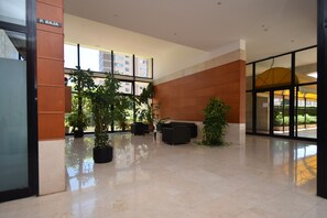 A spacious lobby with a polished floor, potted plants, and a seating area. - Torre Ipanema 9D in Benidorm (Benidorm)