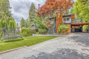 A modern house with a two-story design, a visible garage, and a well-maintained lawn. - Modern Mid-Century Home - Solarium, Deck and Jacuzzi (North Vancouver)