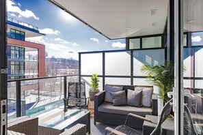A balcony with a sofa, chairs, and a potted plant. - Beautiful 2 Bedroom at Caban (Kelowna)