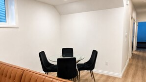 Un interior moderno con una mesa redonda de vidrio, sillas negras y un sofá de cuero marrón.
