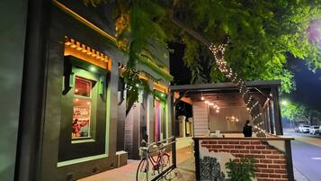 A restaurant with a brick facade, outdoor seating, and string lights.
