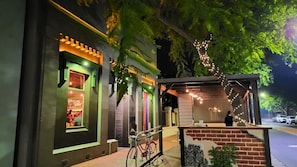 A restaurant with a brick facade, outdoor seating, and string lights.