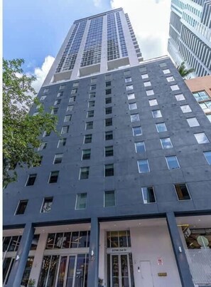Un edificio moderno e imponente, caratterizzato da ampie vetrate e un ingresso ben visibile.