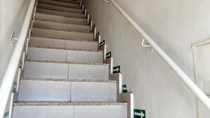 A staircase with handrails and directional arrows on the walls.