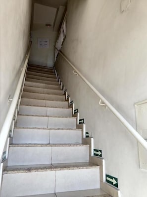 En trappa med ledstänger och riktningspilar på väggarna.
