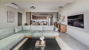 Een moderne woonkamer met een modulaire bank, een salontafel en een televisie.