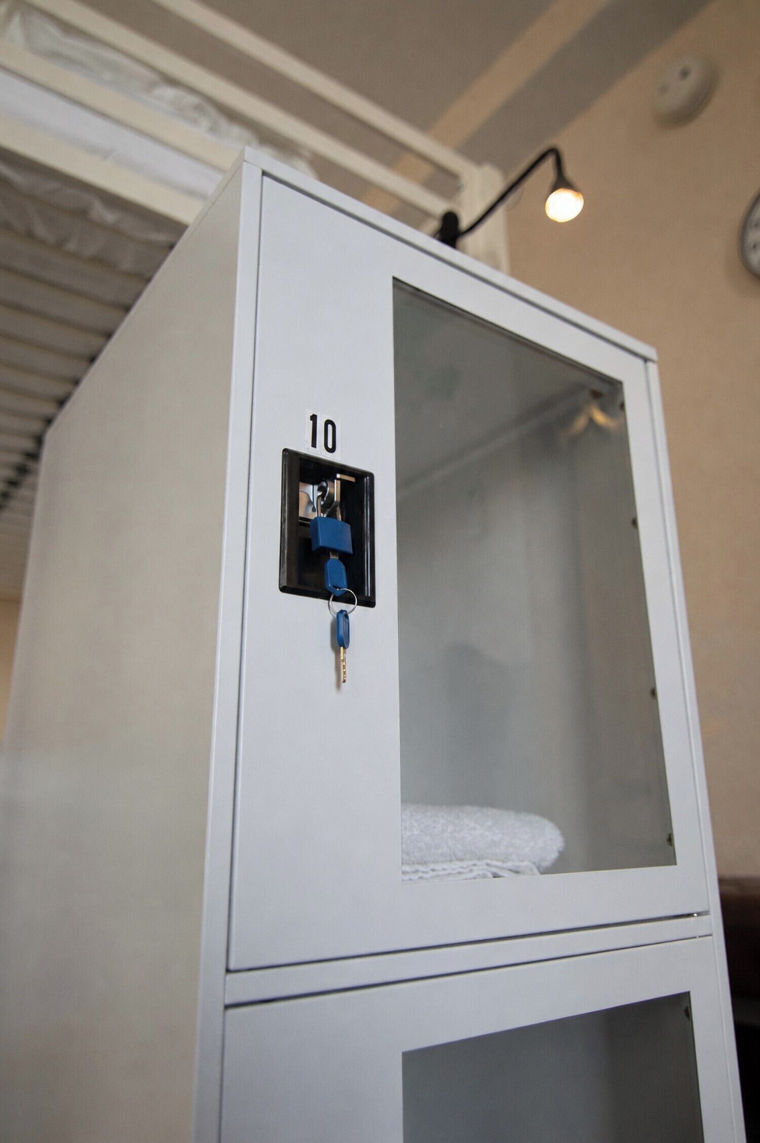 A white cabinet with a lock, a number '10' on it, and a towel inside.