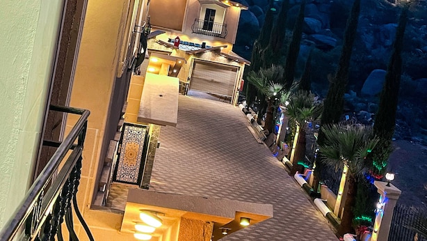 Um hotel com varanda, área externa para sentar e vista para a paisagem ao redor.